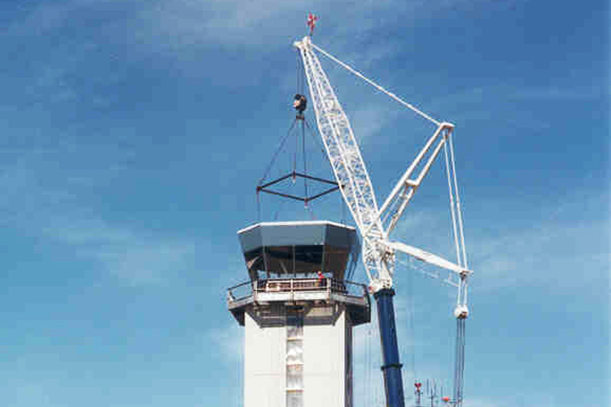 The control cab rigged and hoisted into position on the tower