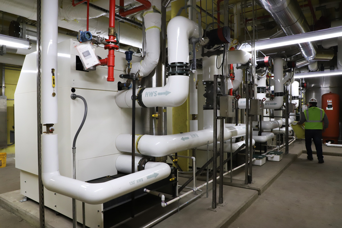 Finishing the installation of the four-unit gas fired hydronic heating plant.